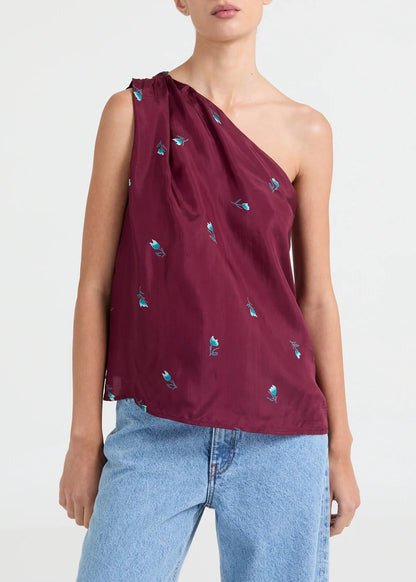 Asymmetric one-shoulder top with a soft drape and understated floral print. Designed for an elegant, contemporary look.